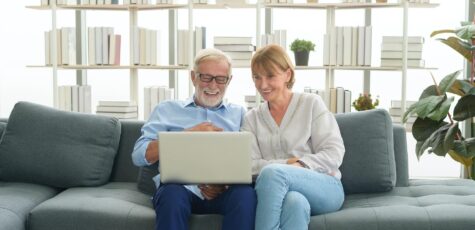 Man and woman on a laptop searching when they need to drawdown their penison