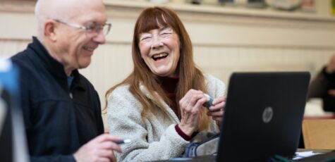 A retired man and a retired woman discussing the differences between pension drawdown and an annuity as a retirement option.